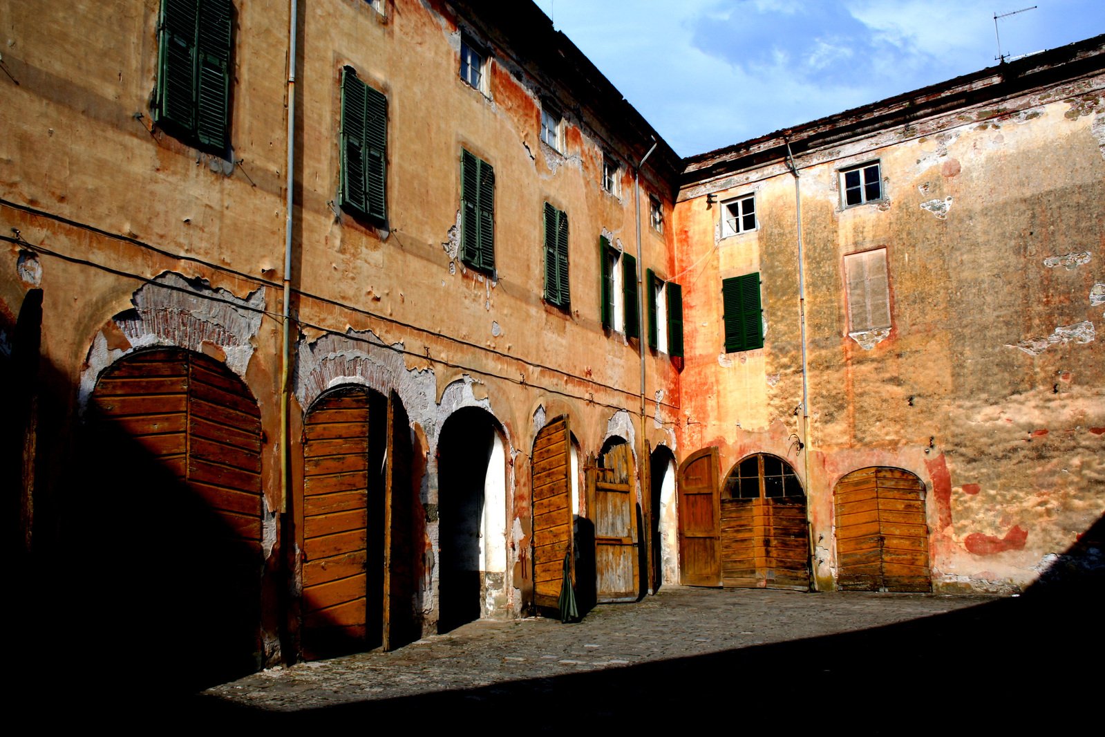 a large, old building with green shutters and arched windows