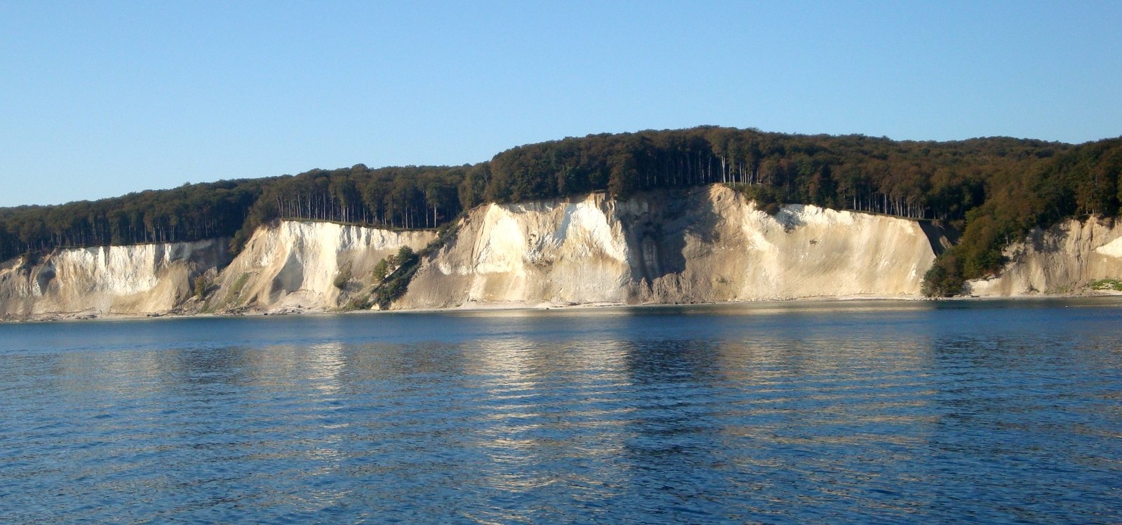 some hills next to some blue water and a lake