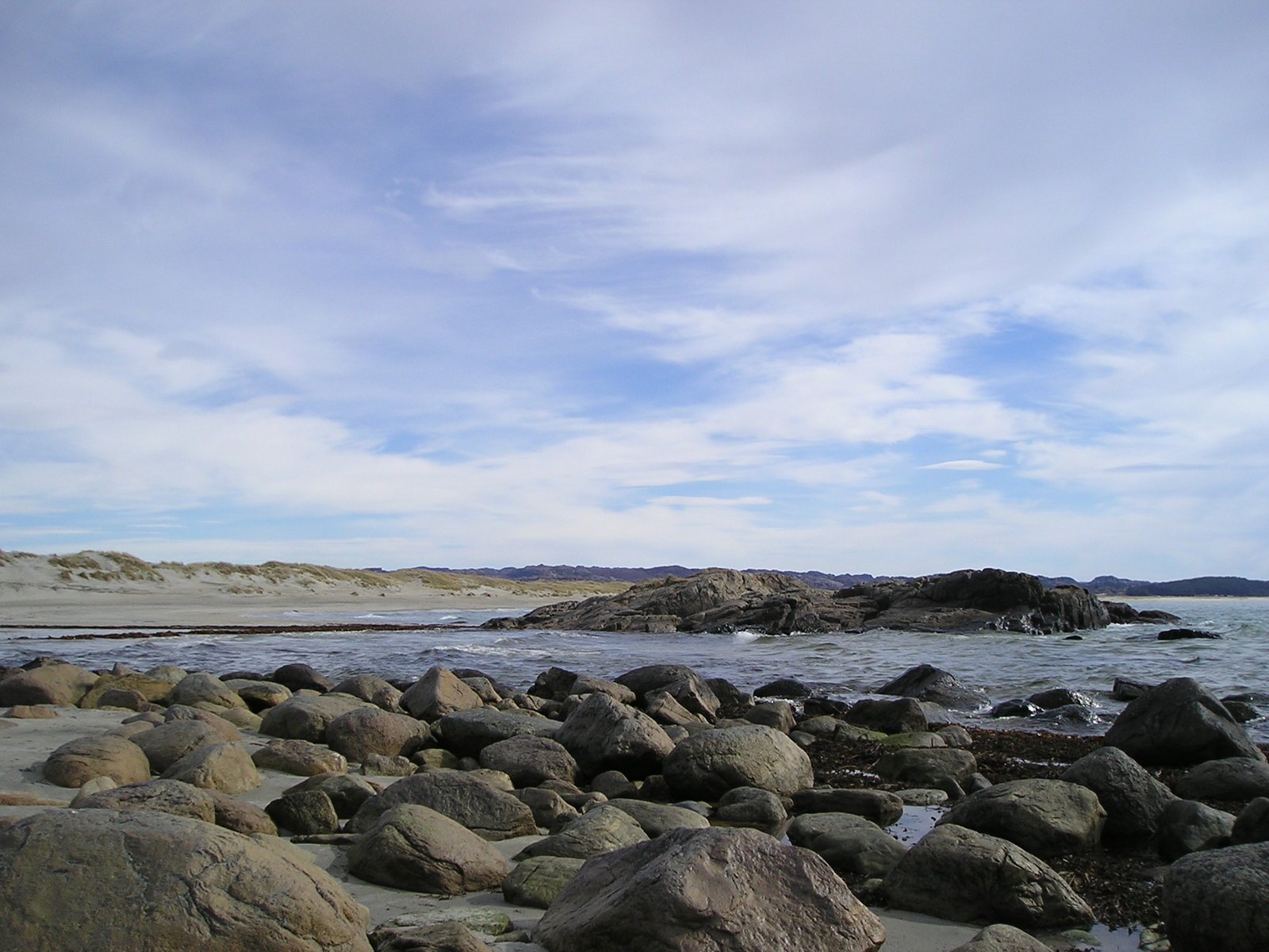 rocks are on the shore near a beach