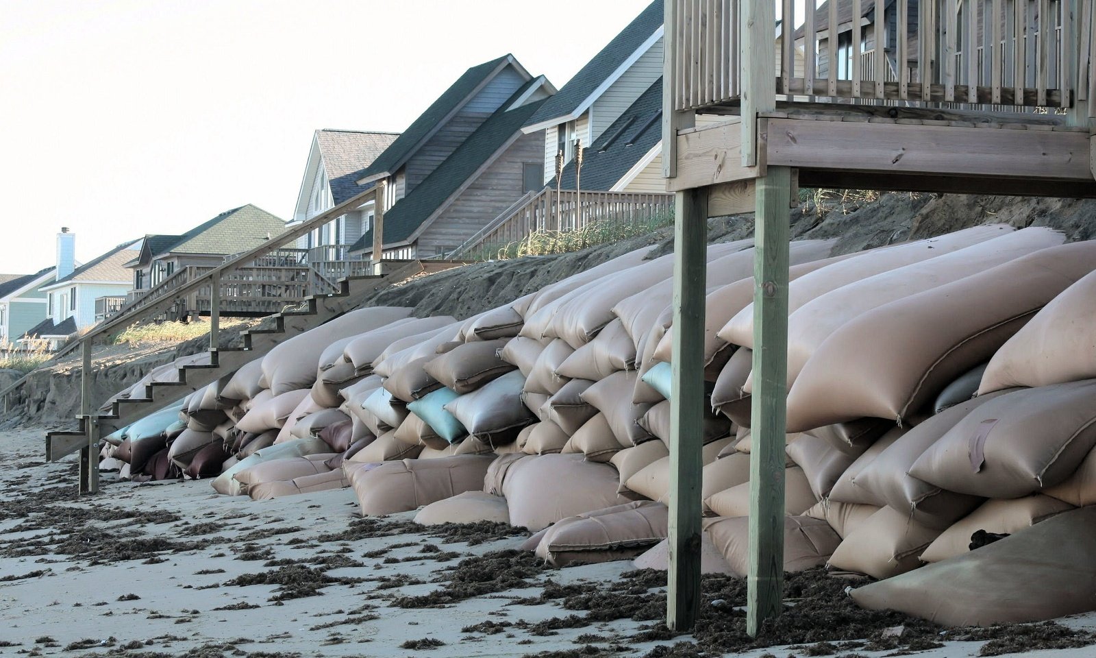 bags and pillows lined up next to a wooden deck on the beach