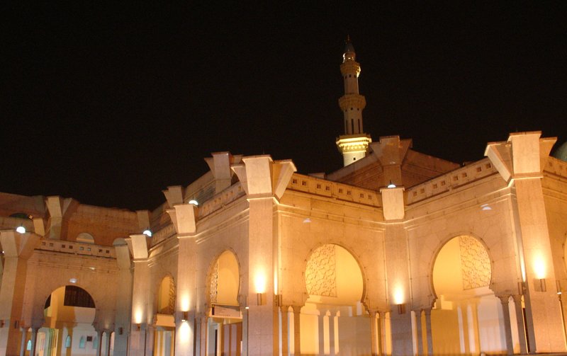 an intricately lit building with columns on both sides at night
