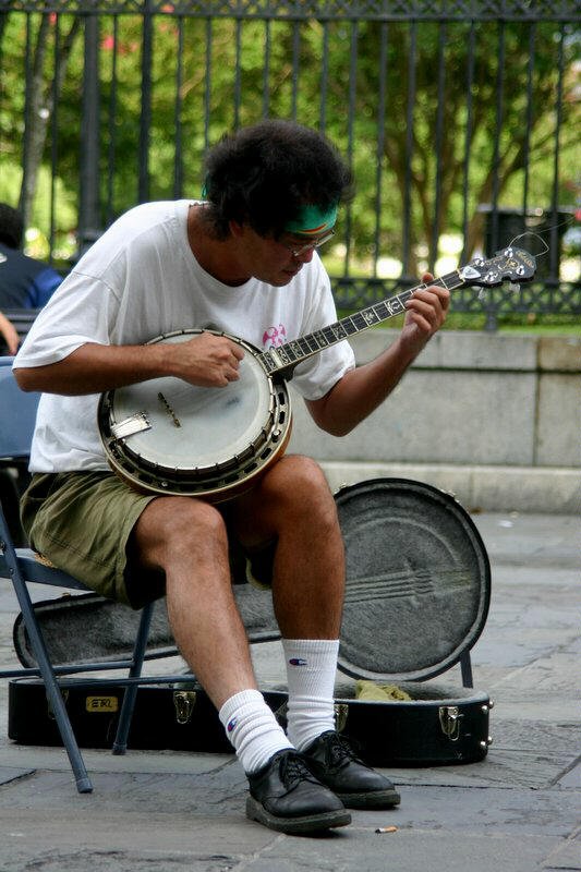 a man sitting on a bench playing the guitar