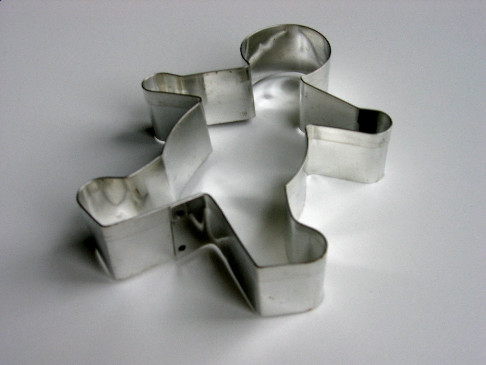 four metal cookie cutters laying on a white surface