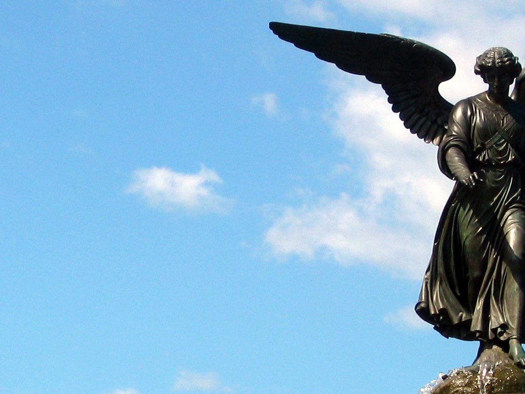 there is a black angel statue on top of the hill