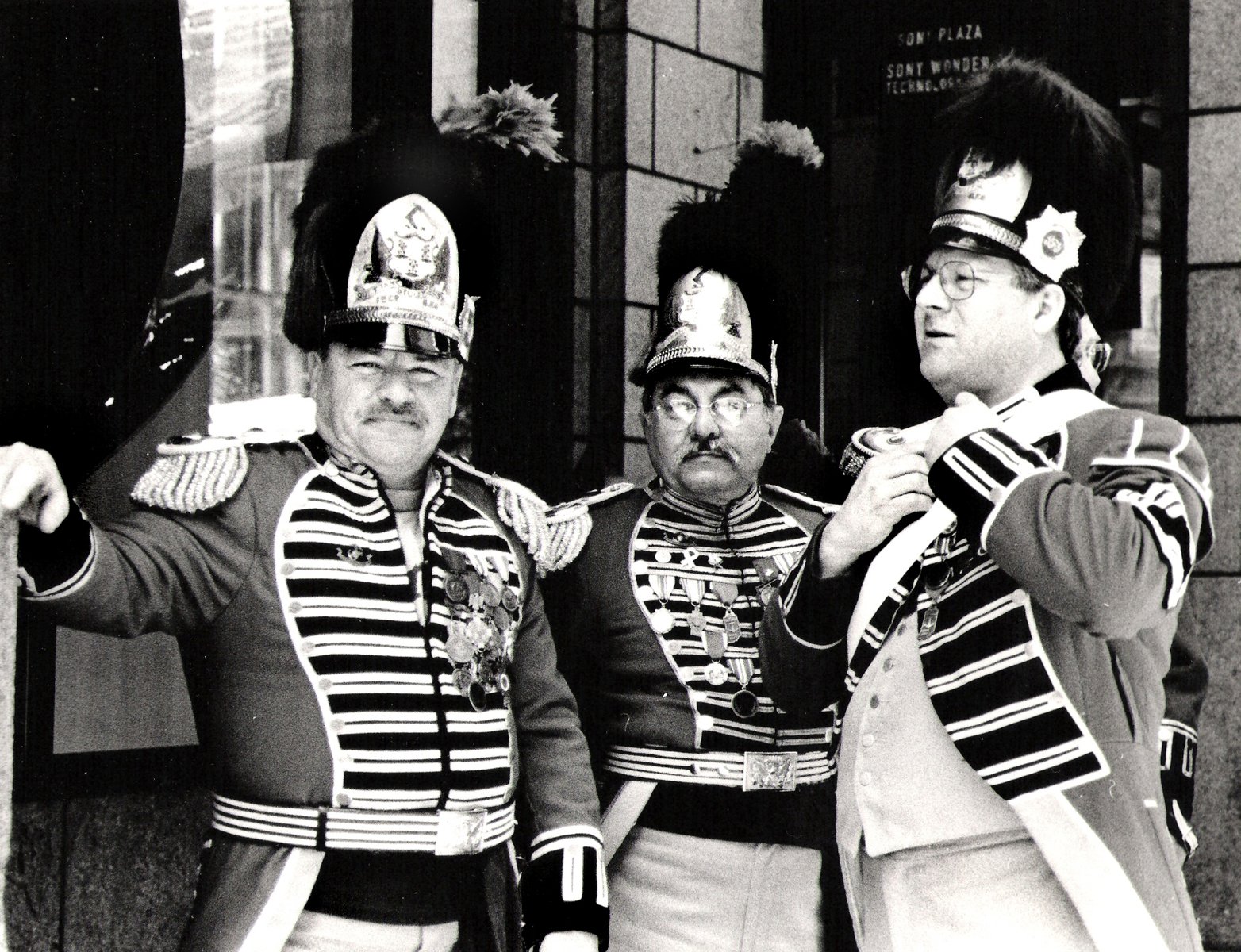 some military men in striped uniforms standing on the street