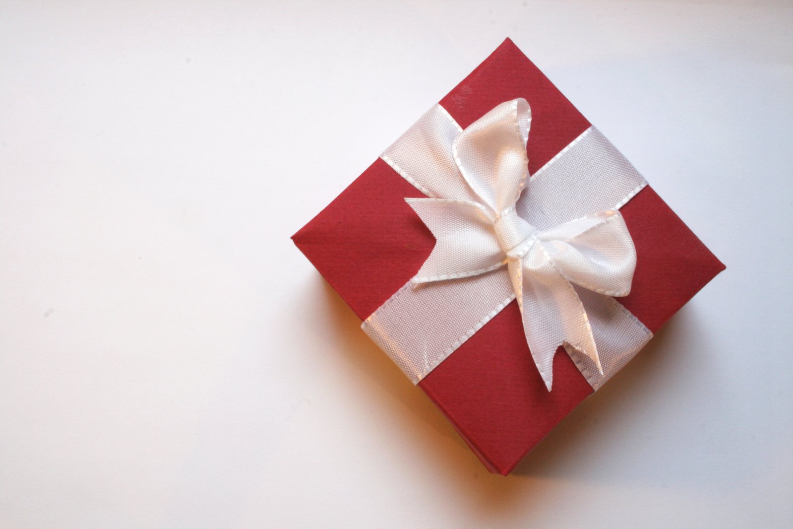 a red gift box with a white ribbon