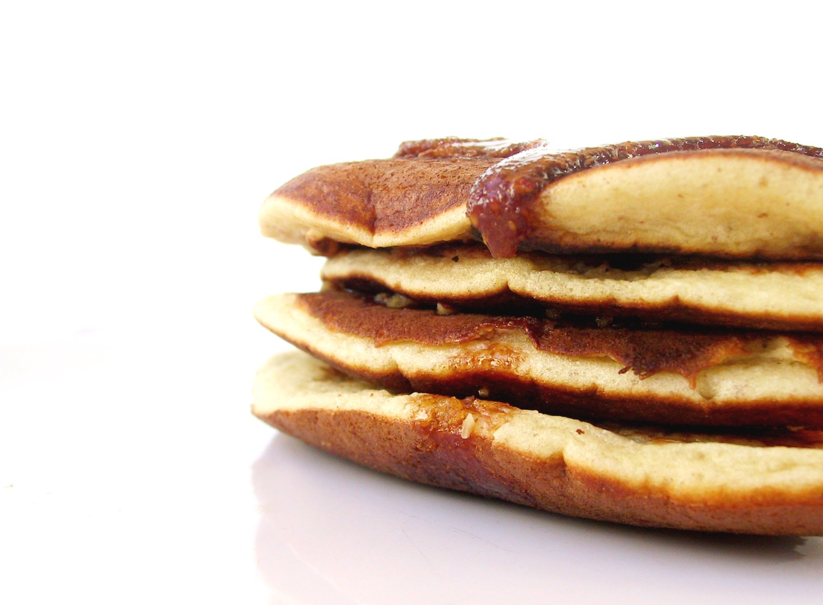 several pancakes with syrup and chocolate spread on them