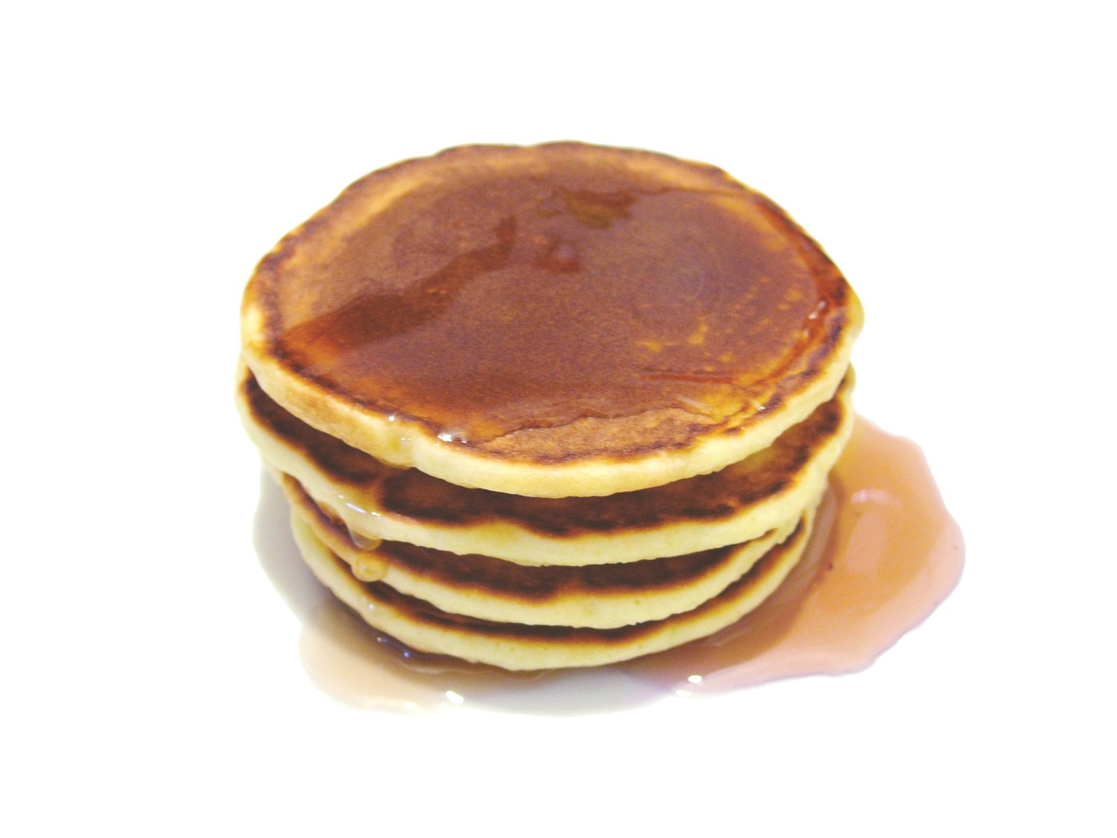 a stack of pancakes with syrup sitting on a white surface