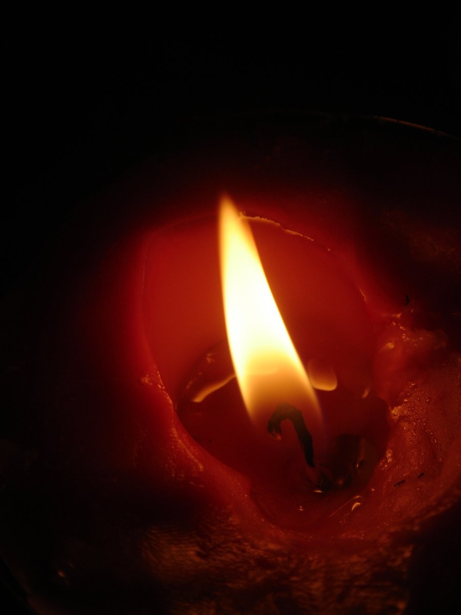 a red candle in the dark with one light on