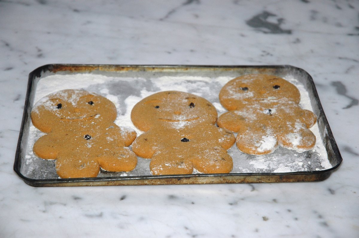 some sugar cookies in the shape of bears on a baking sheet