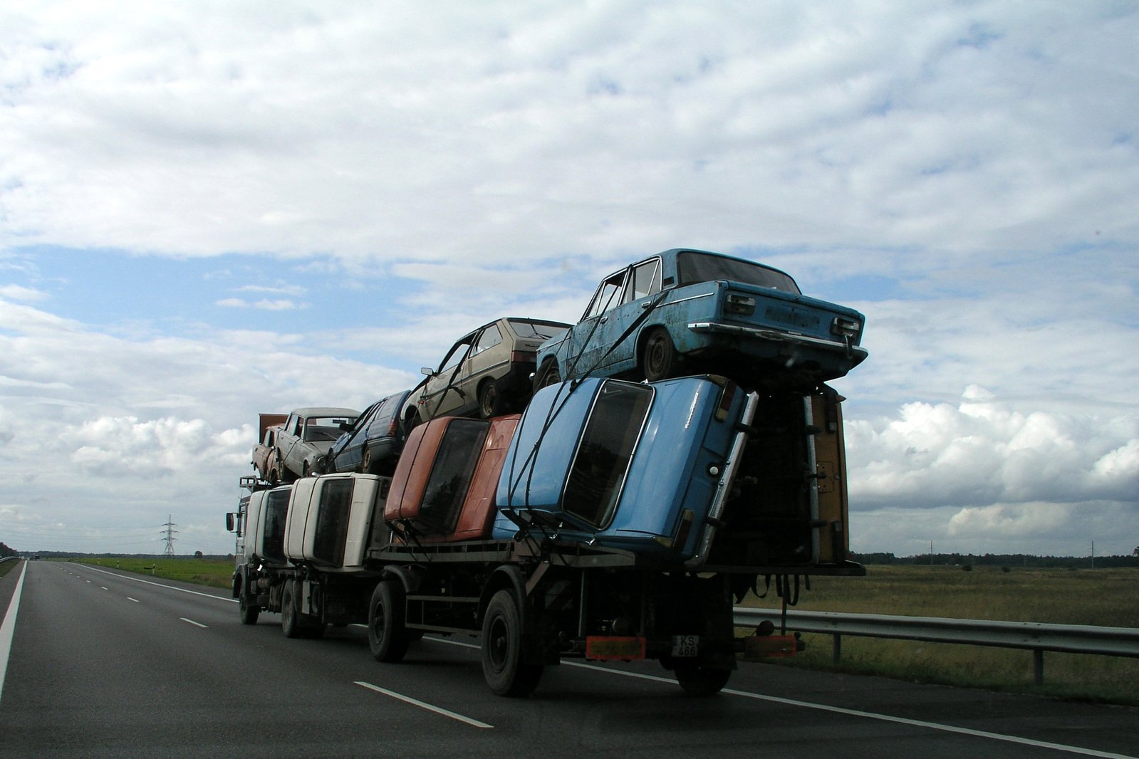 a row of trucks carrying junk on a highway