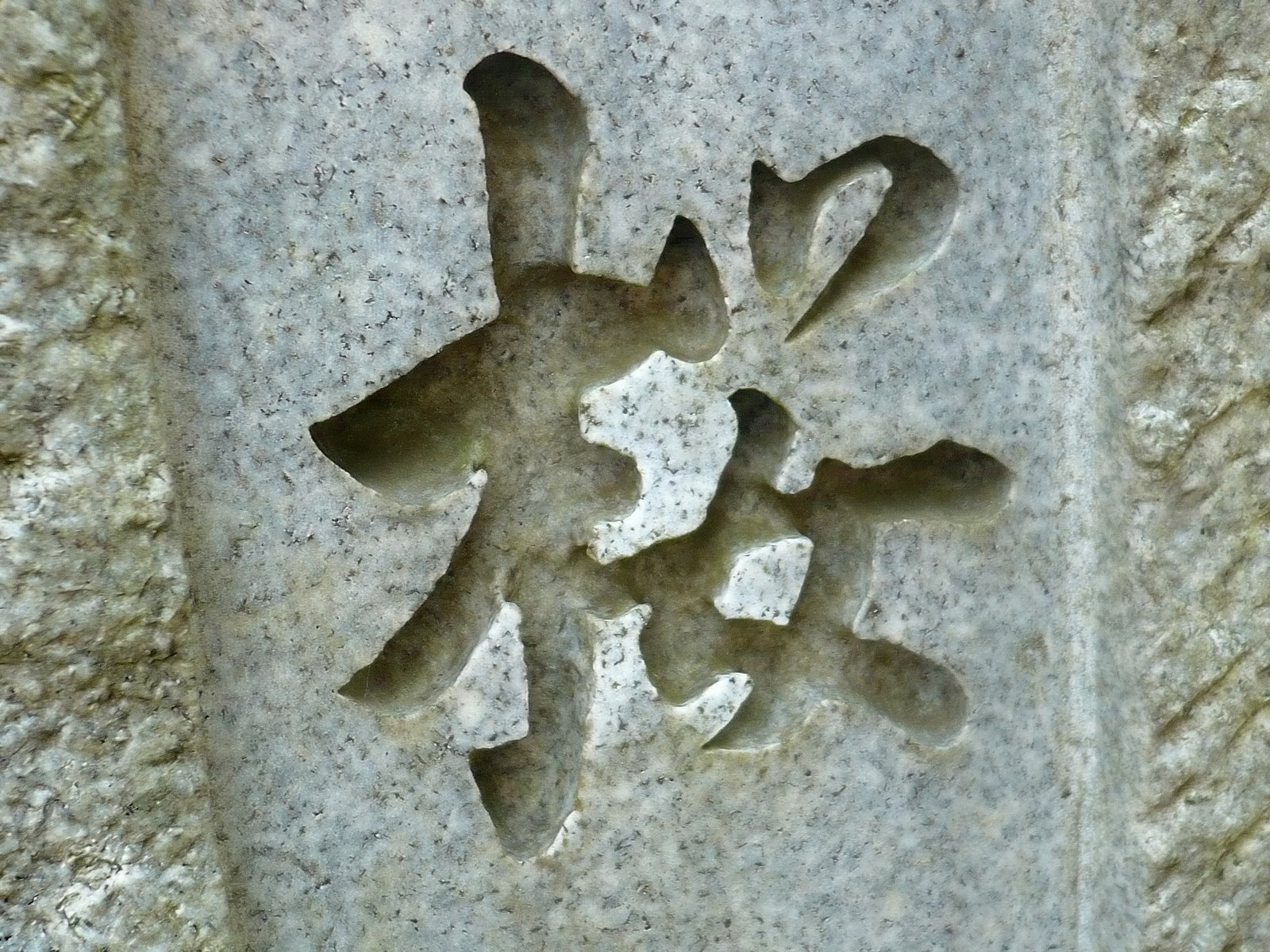 an asian symbol is carved into the stone wall