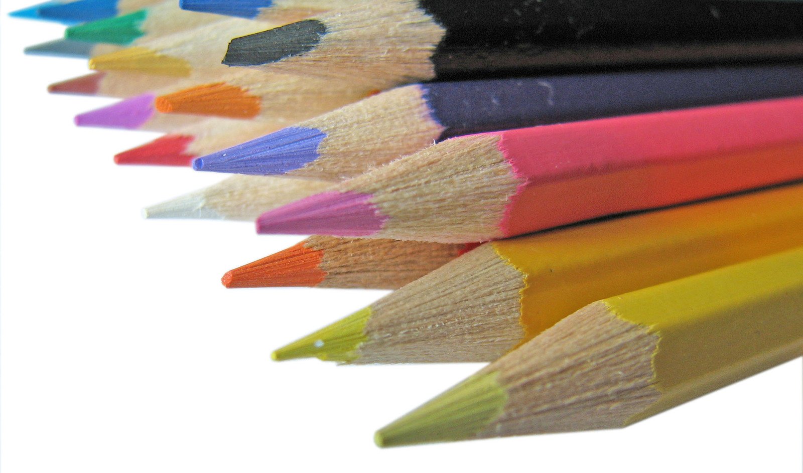 a group of colored pencils sitting on top of each other