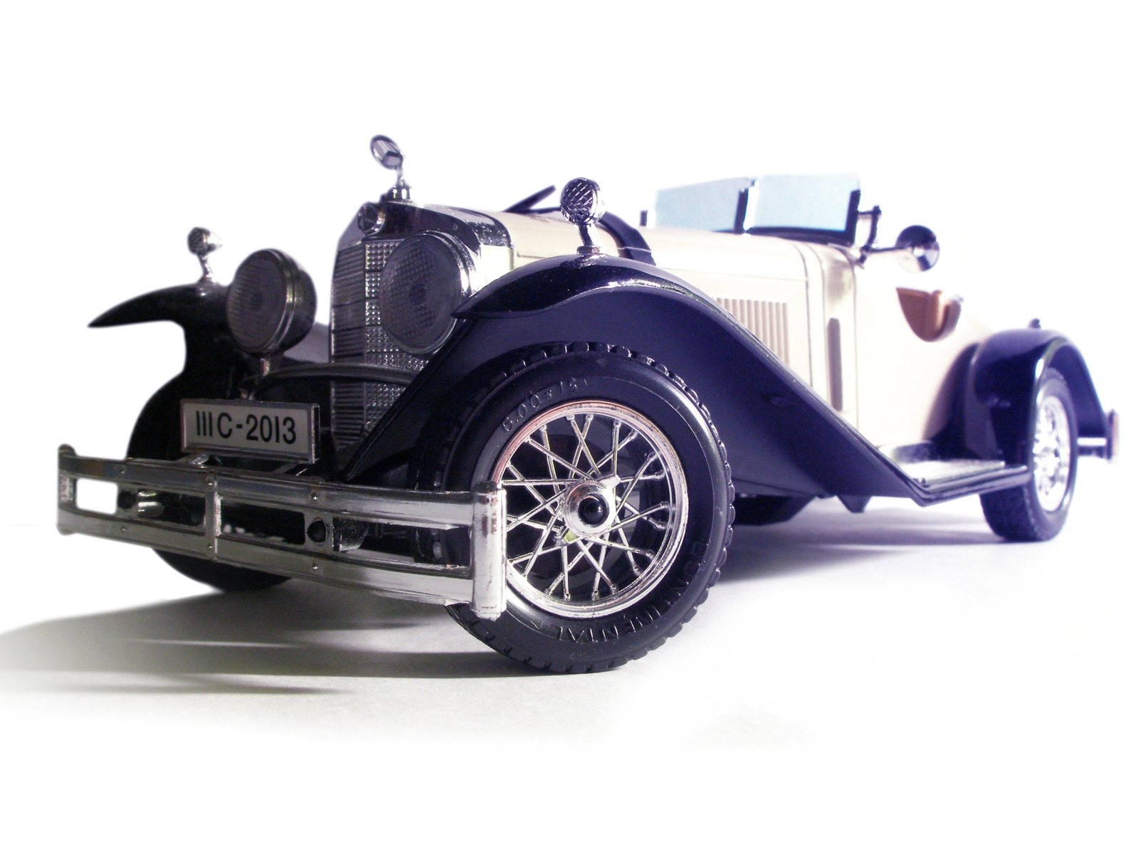 a toy antique model car with the doors open