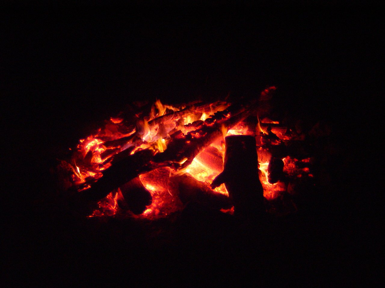 a glowing, open fire in the night on black