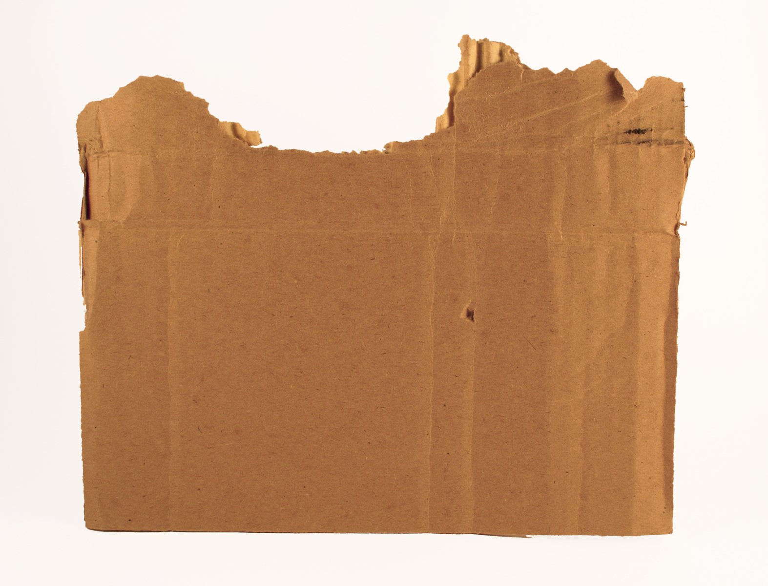 an old piece of brown paper with torn pieces of cardboard on top