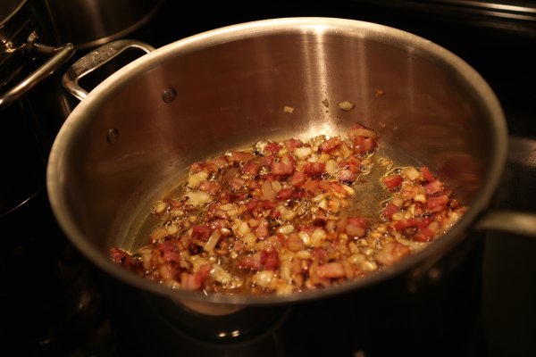 some bacon and onions are frying in a pan