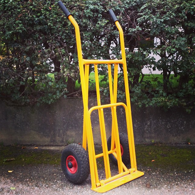 a hand truck with two wheels and a red wheelbarrow