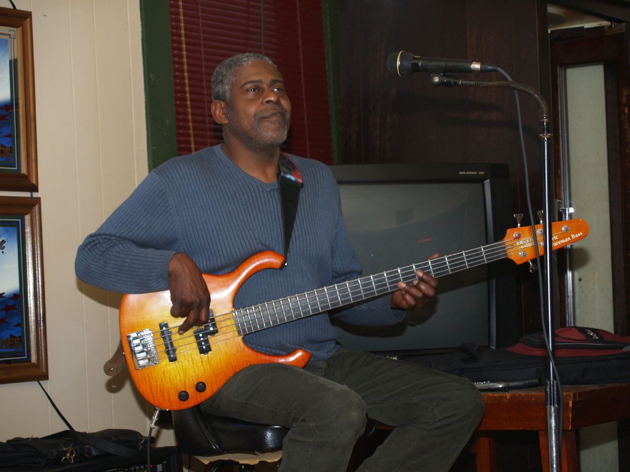 a man with an orange guitar is playing on a keyboard