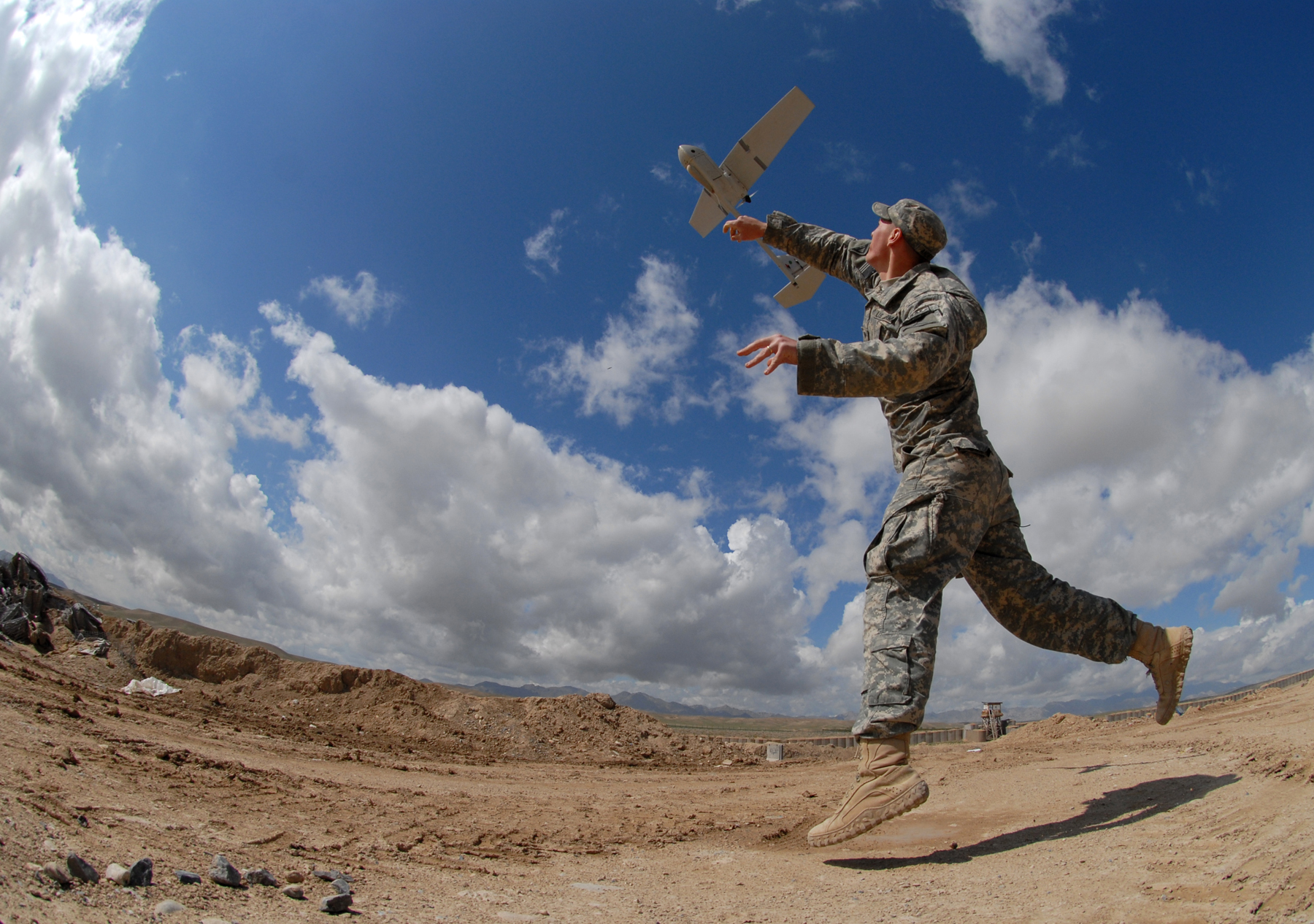 a person on a dirt surface with a flying object in the air