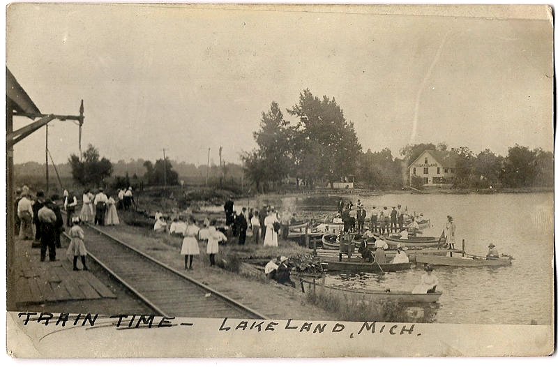 an old po shows people near the train tracks