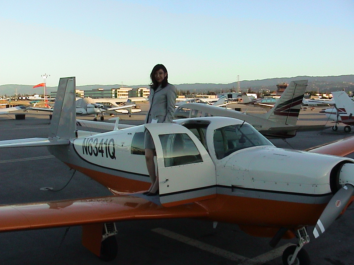 a man is standing in front of an orange and white plane