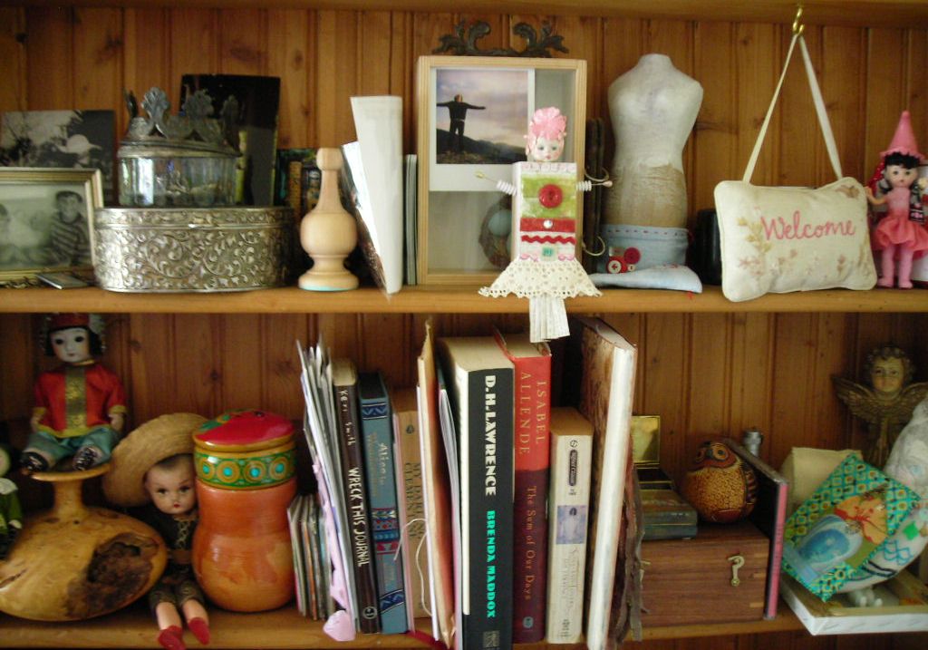 several books on a wooden shelf near other decorations