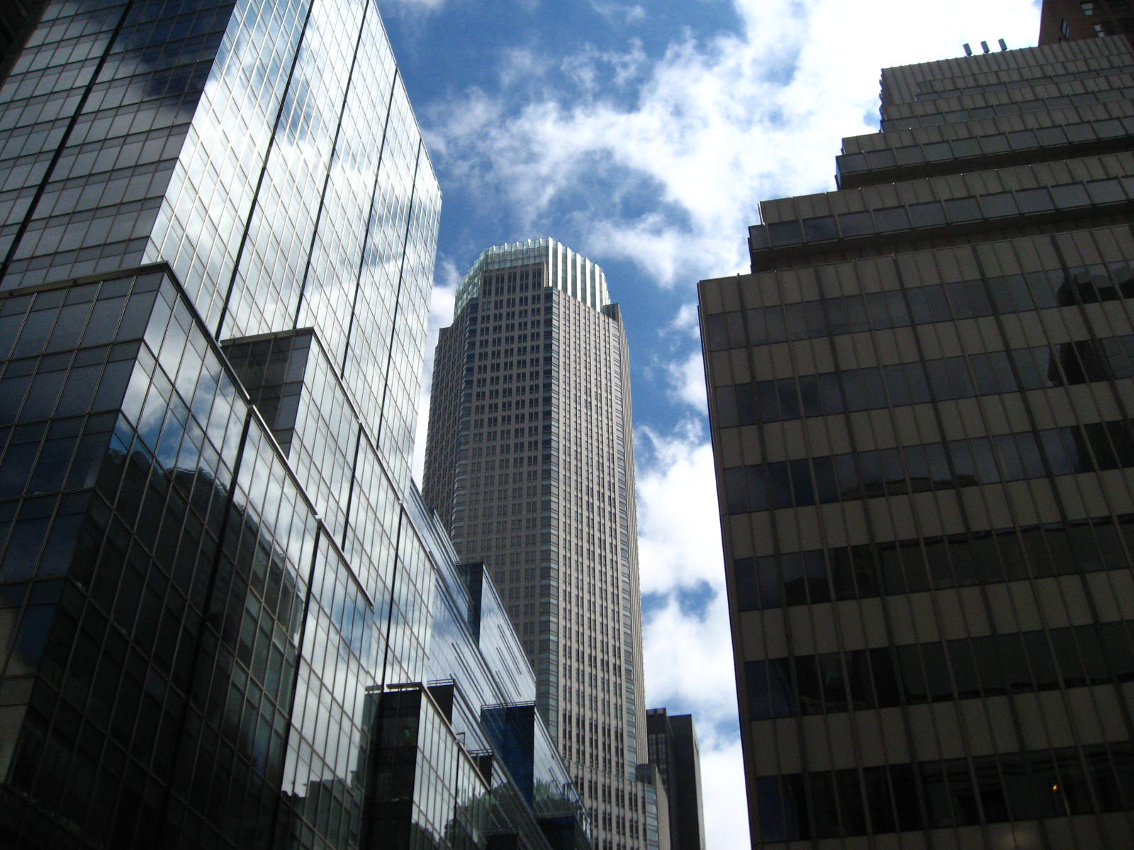 two skyscrs in front of a blue cloudy sky