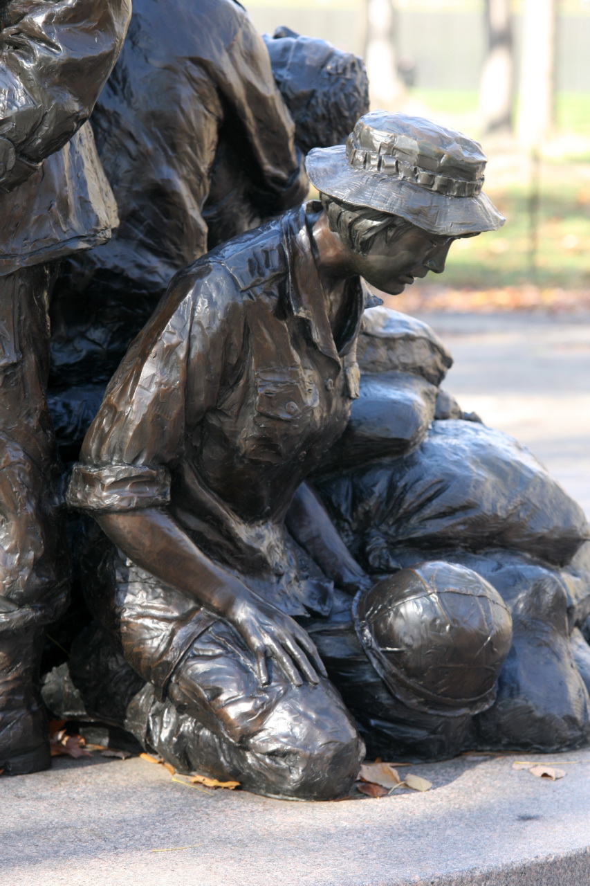 statue of a boy helping another boy fix his hat