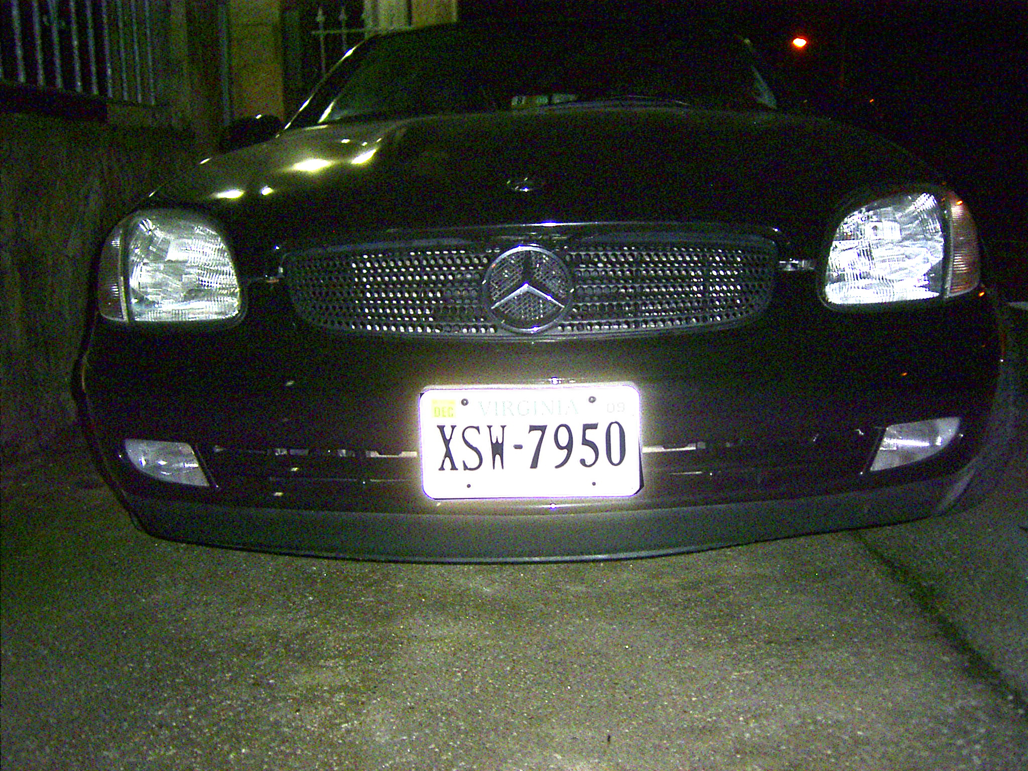 black mercedes in the street at night with the license plate