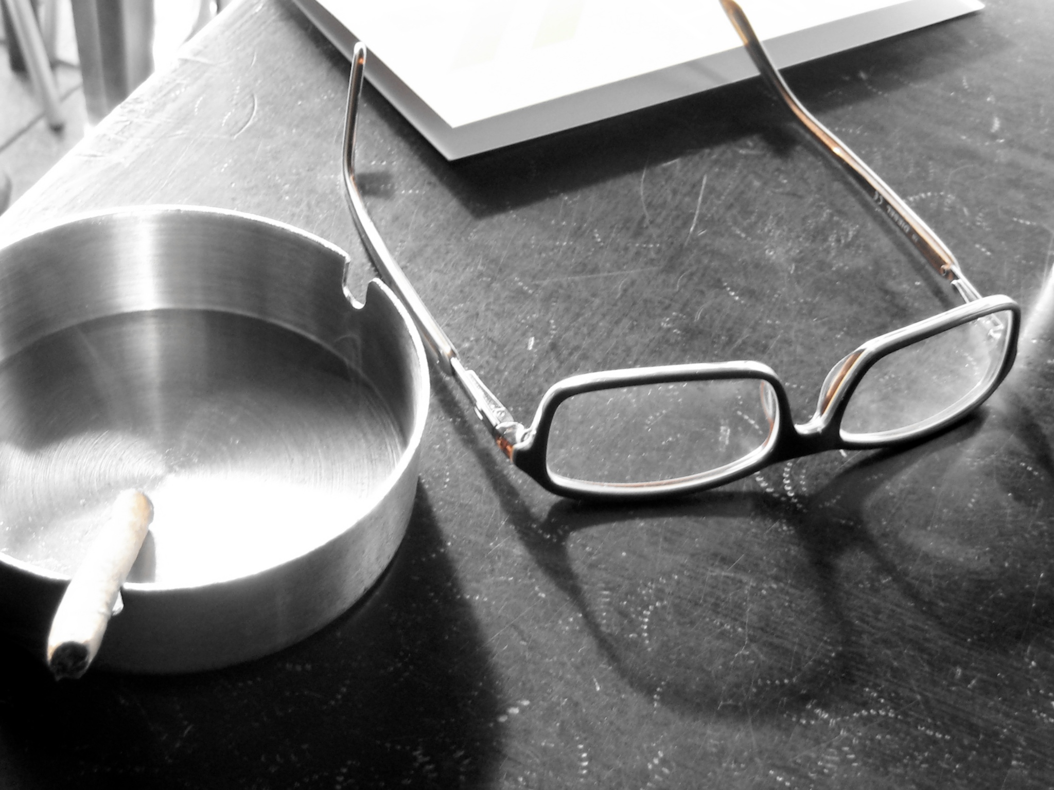 an eyeglass sitting next to a frying pan on a table