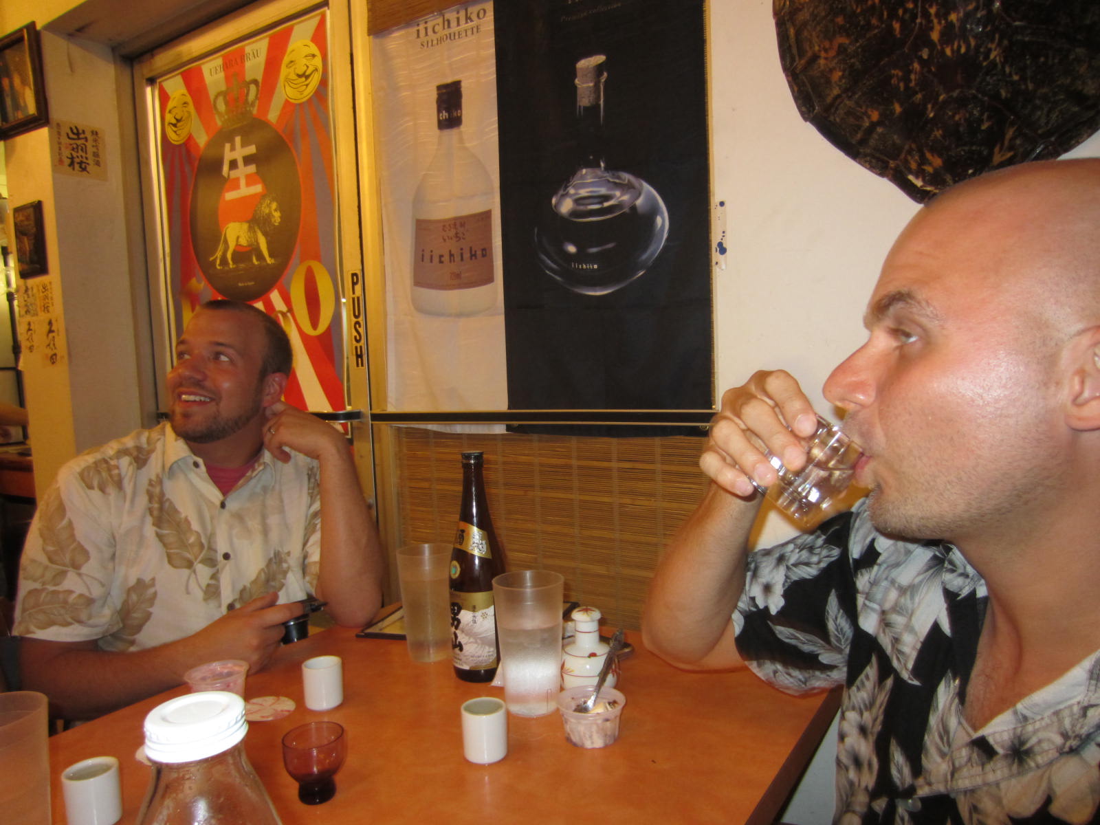 two men are enjoying some alcohol at a restaurant