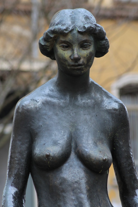 a statue of a woman with a long skirt is outside