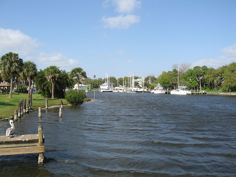 a river near some boats is empty and blue