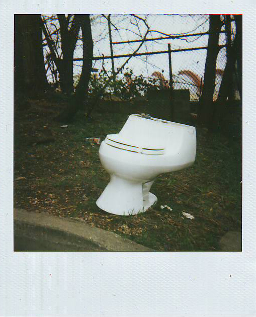a toilet sitting in the grass by itself