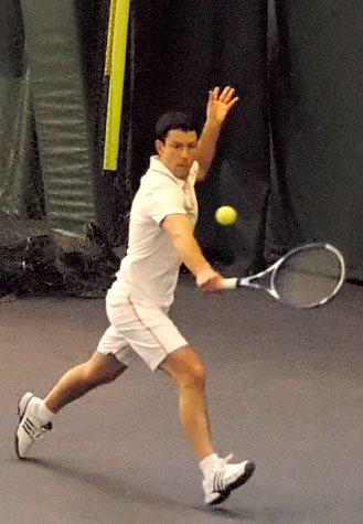 a male tennis player in a white shirt is playing tennis