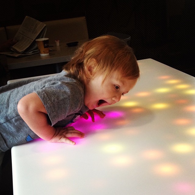 a young child looks at a lit up surface