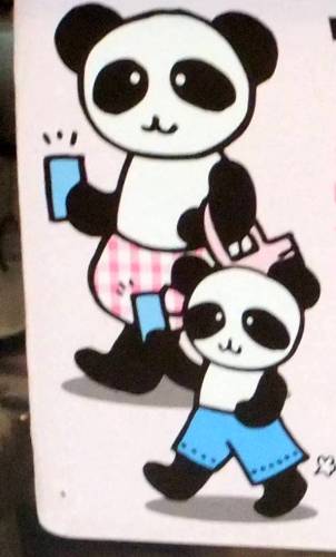 a panda bear holding up a small panda bear with its arm