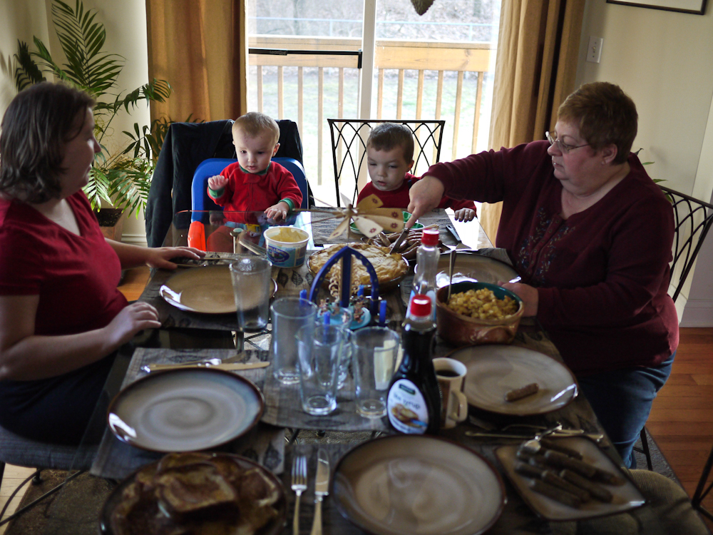 three people sitting around a table eating a meal