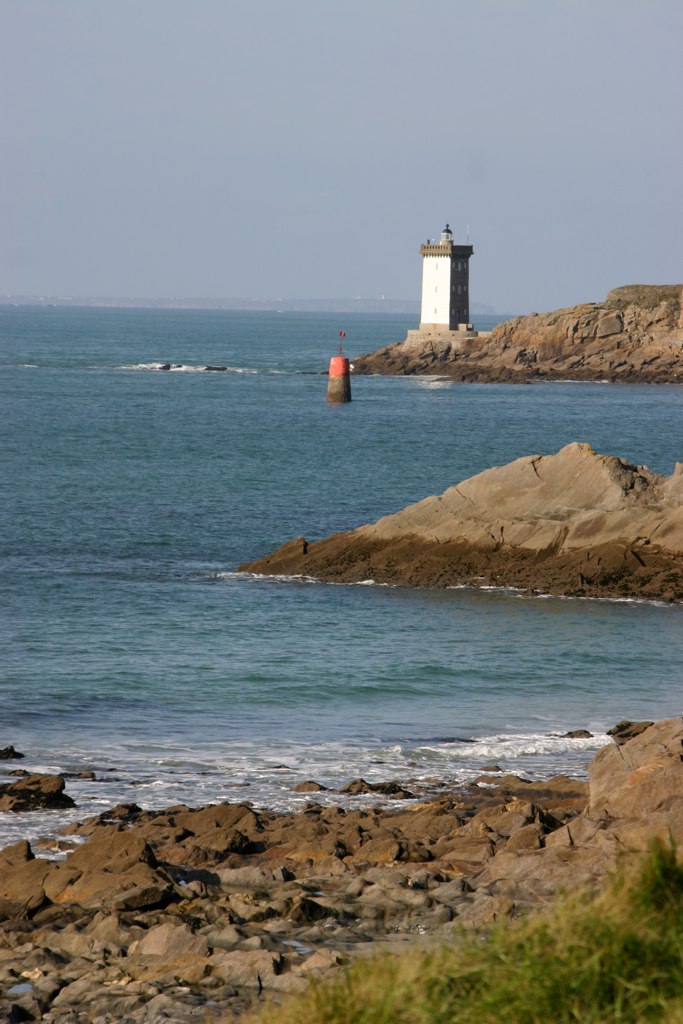 two lighthouses off the coast near a beach