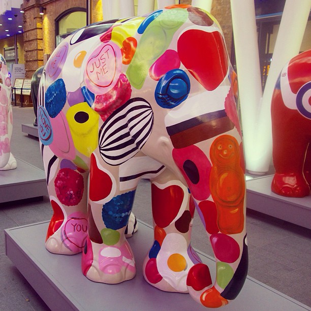 an elephant made from various types of things is in front of a store display