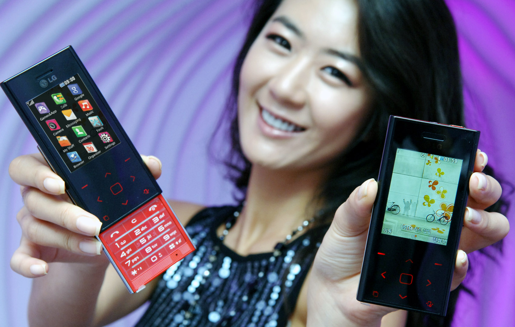 a young woman is holding two colorful phones
