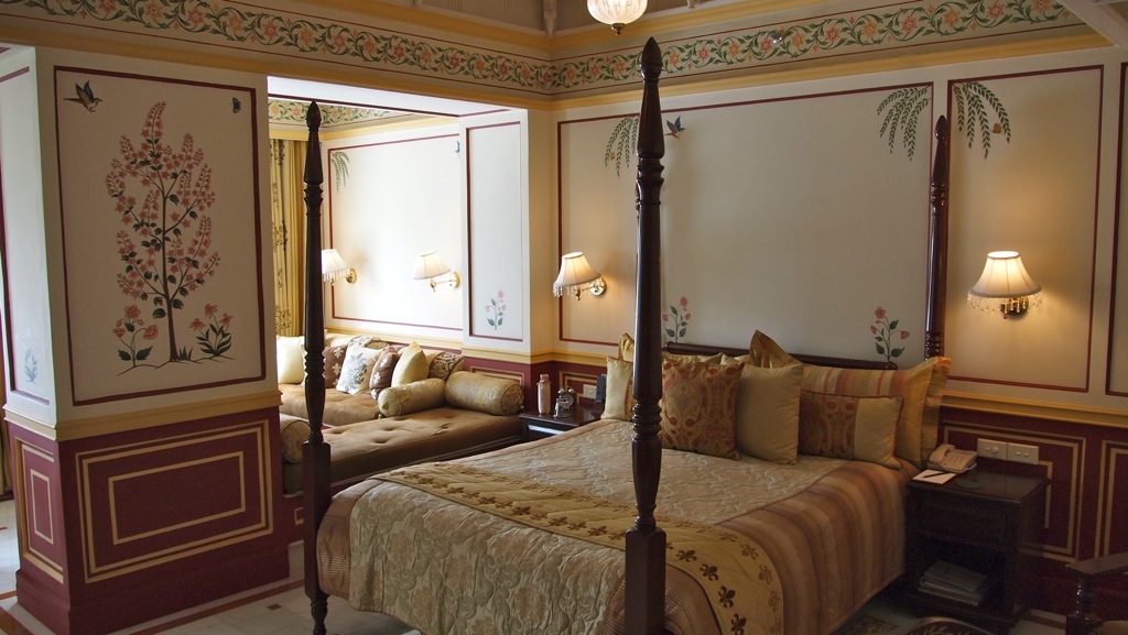 a four post bed is decorated with a golden floral pattern