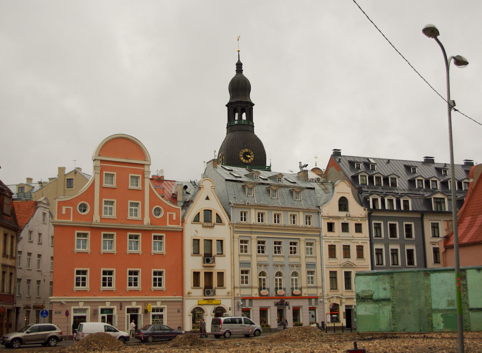 a view from behind the corner of some buildings looking toward the tower