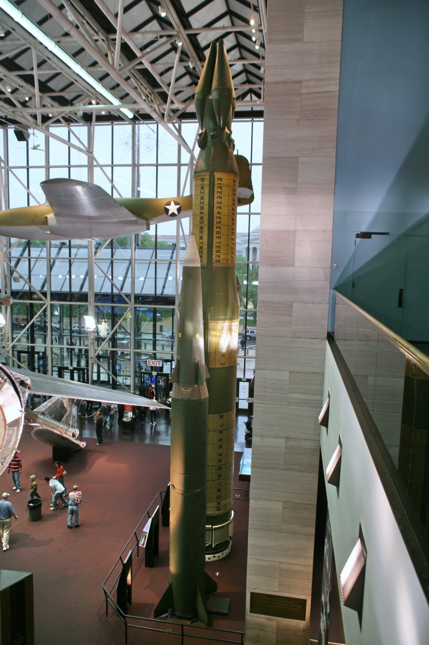 there is a very tall model rocket inside the museum