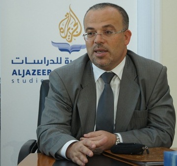 an arabic businessman at a table with water behind him