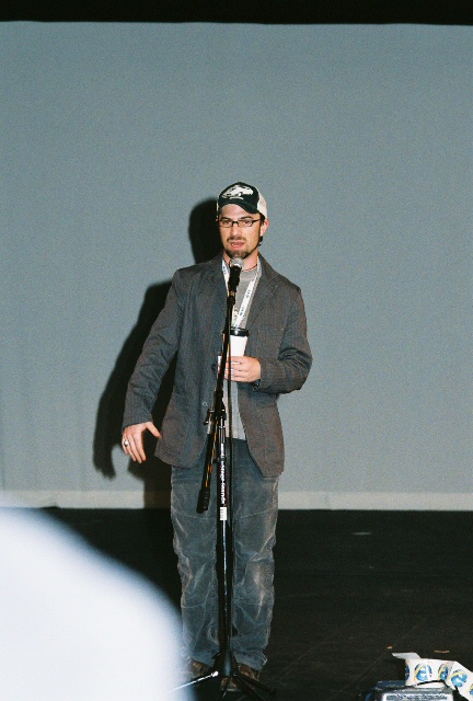 a man standing at a microphone talking to someone