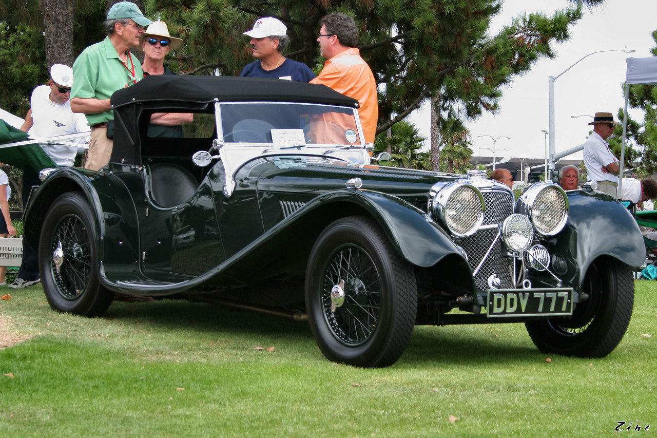 an old car with a bunch of people watching it