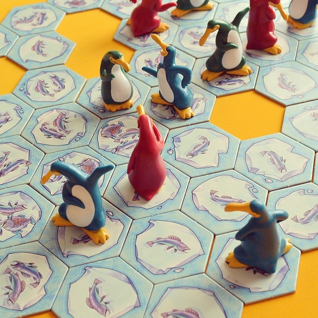 some colorful penguins sitting on a pattern board