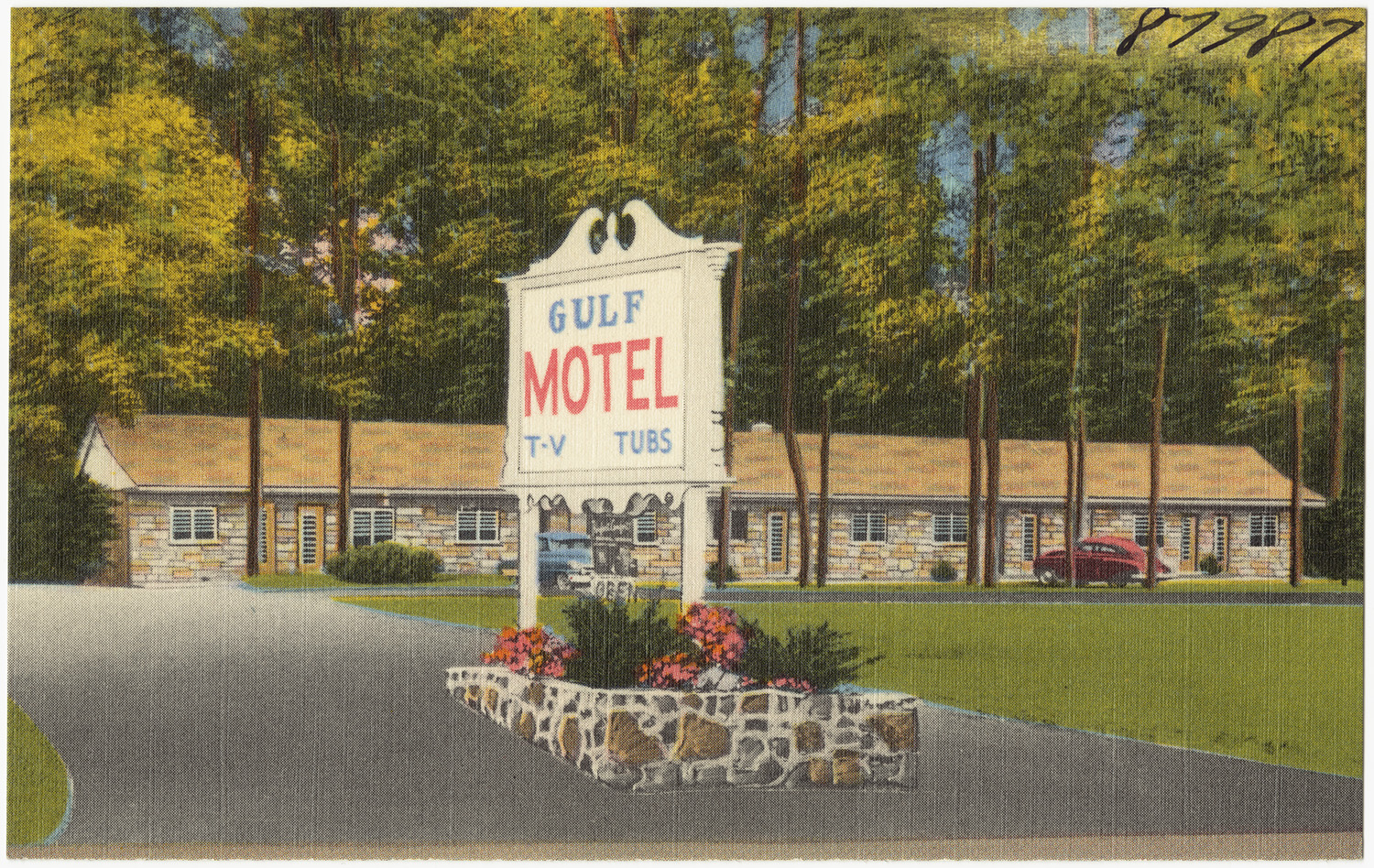 an image of motel sign with plants on the side of the road